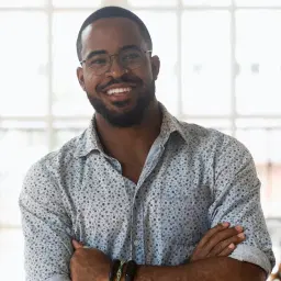 headshot of Smiling confident african american young businessman standing with folded hands, looking at camera