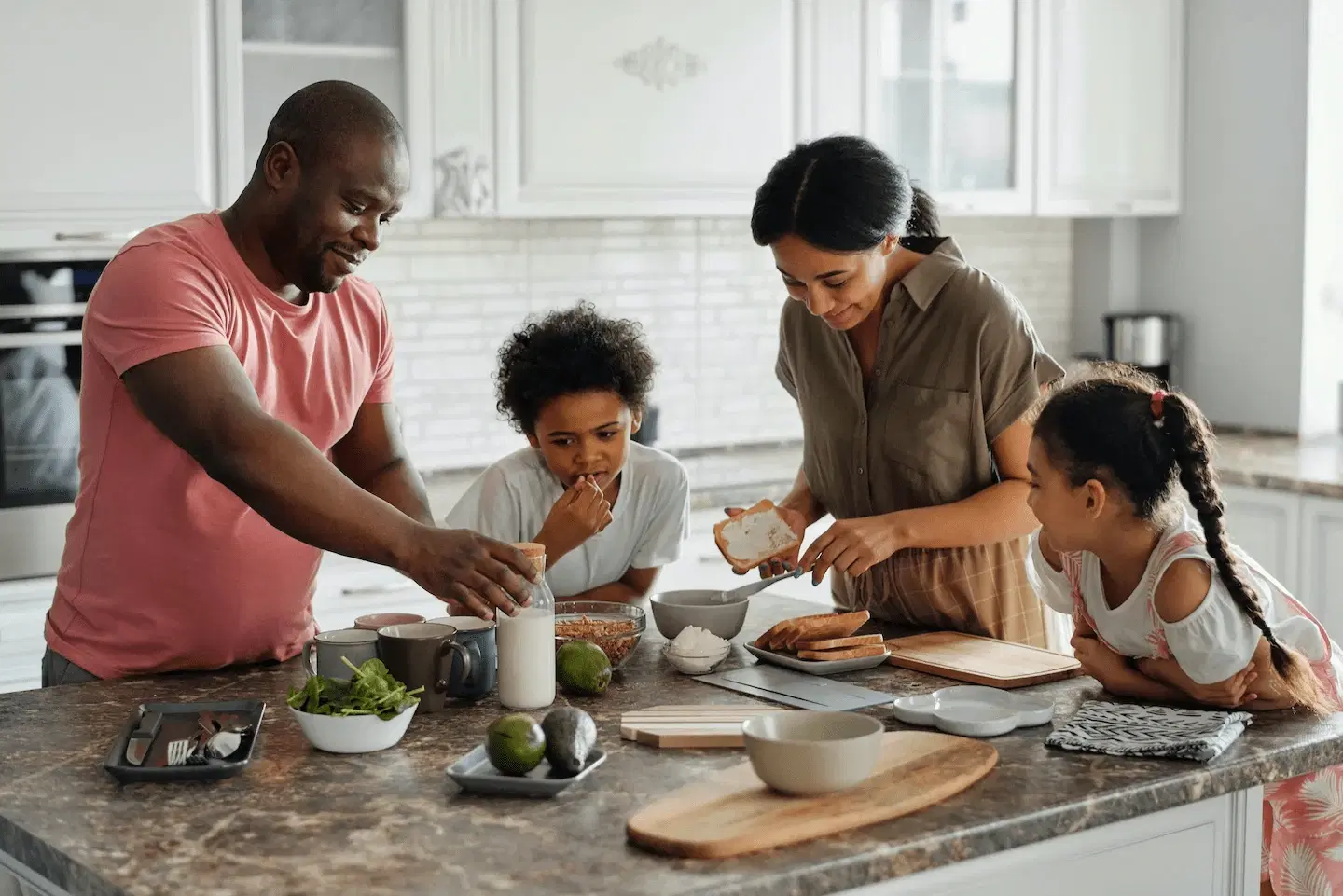 Family of three cooking breakfast at a kitchen counter