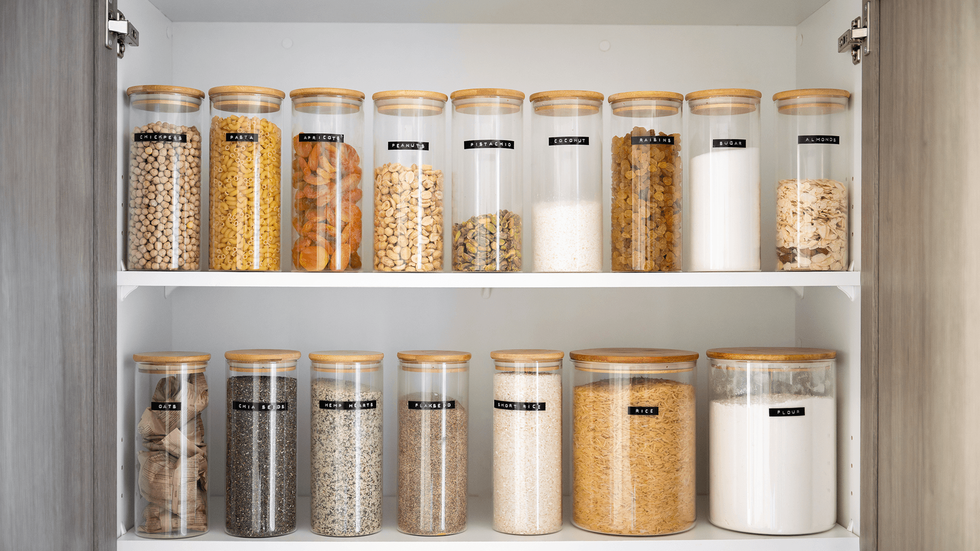 Pantry shelves with dry goods stored in labeled airtight containers to help prevent pantry pests
